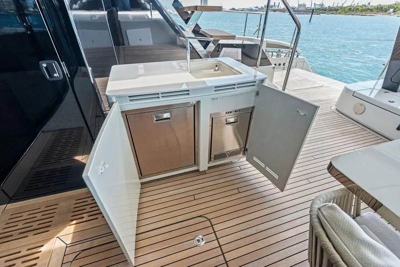 Slide: The Image of Outdoor kitchenette on 2024 Sunreef 80 Power yacht with open cabinets and ocean view. - 23