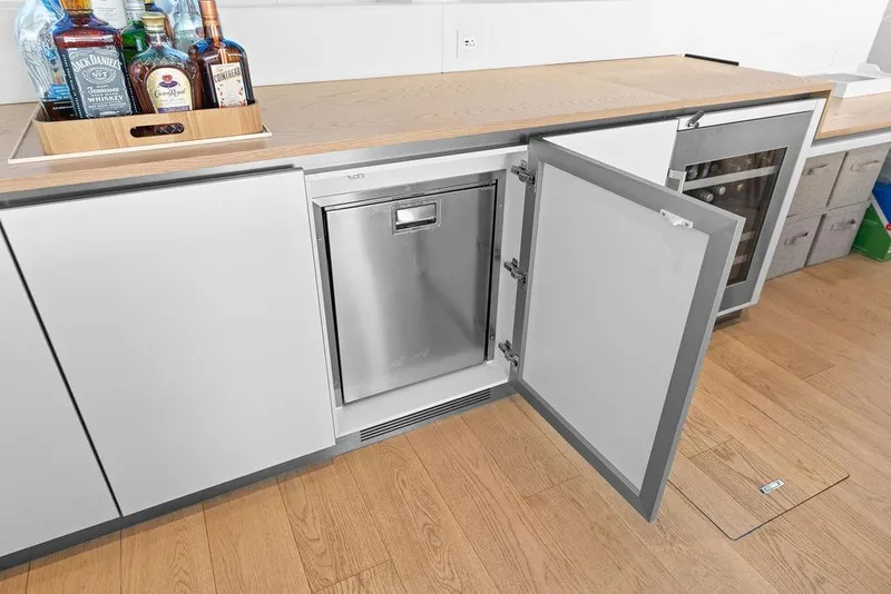 Slide: The Image of Modern kitchen on 2024 Sunreef 80 Power yacht with open dishwasher and liquor bottles. - 53