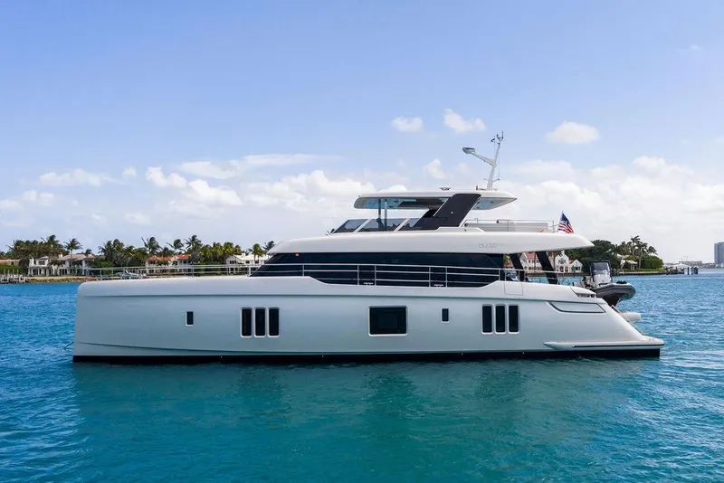 Slide: The Image of 2024 Sunreef 80 Power yacht cruising on clear blue waters. - 7