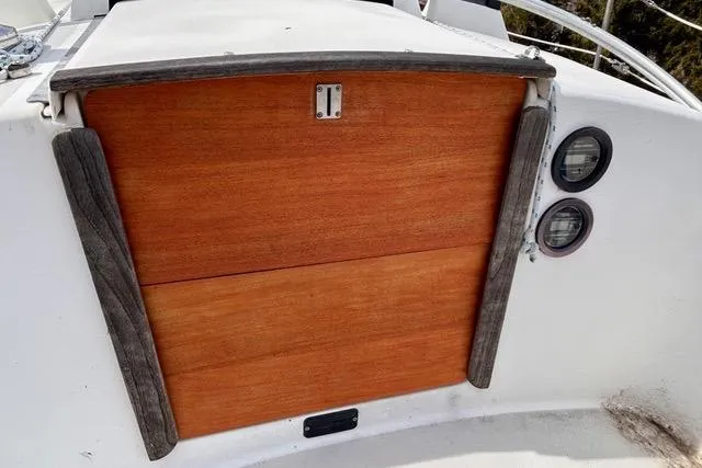 Slide: The Image of 1984 Pearson 34 sailboat on stands, surrounded by trees under a clear blue sky. - 17