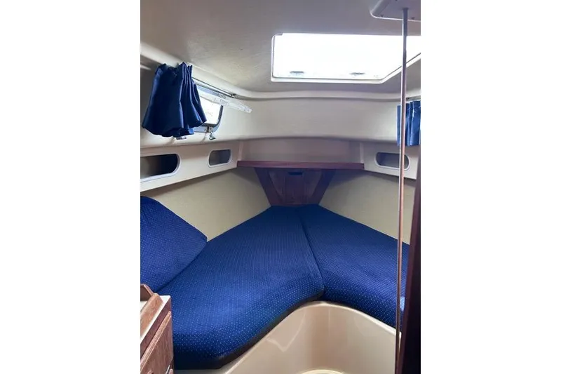 Slide: The Image of Interior of a 1984 Pearson 34 sailboat with blue seating and wooden accents. - 4