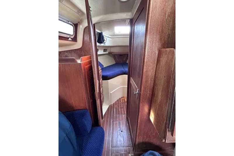 Slide: The Image of Interior of a 1984 Pearson 34 sailboat with wooden accents and blue curtains. - 7