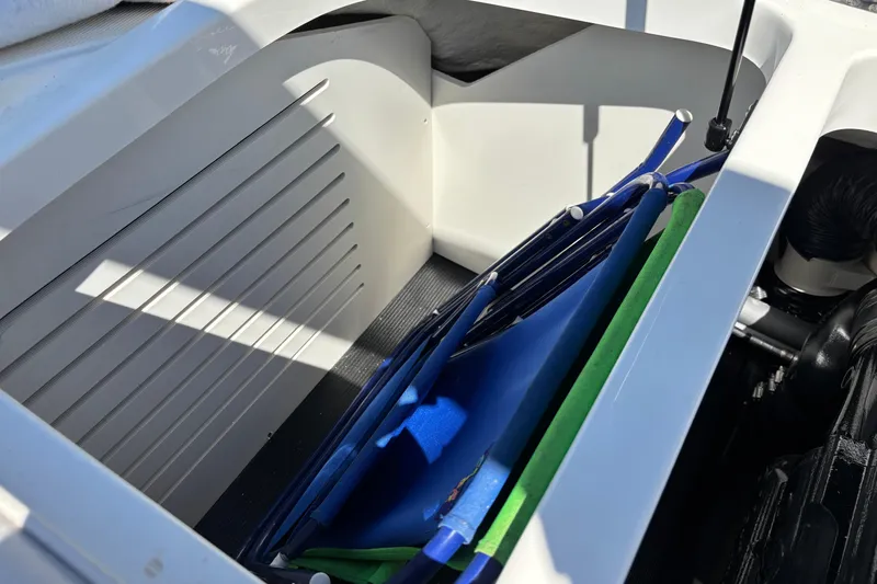 Slide: The Image of Storage compartment in 2024 Sea Ray SPX 210 boat, featuring organized space and equipment. - 16