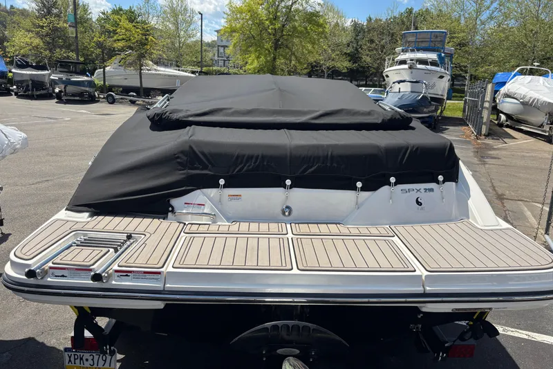 Slide: The Image of 2024 Sea Ray SPX 210 boat with black cover in a marina parking lot. - 5