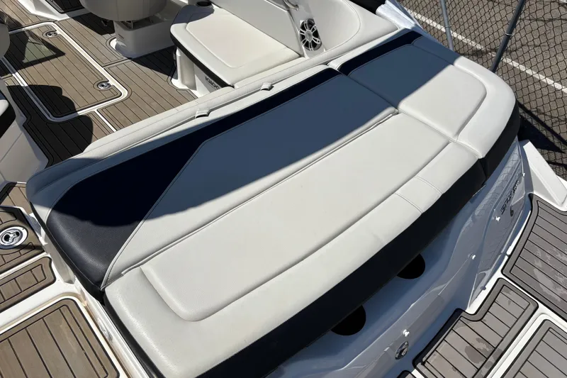 Slide: The Image of 2024 Sea Ray SPX 210 boat interior with cushioned seating and teak-style flooring. - 6