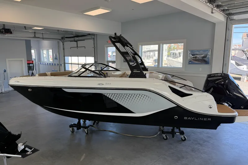 The Image of 2026 Bayliner D22 boat displayed in a showroom, featuring sleek black and white design. - 1