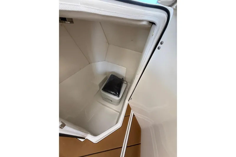Slide: The Image of Storage compartment inside 2026 Bayliner D22 boat, featuring a compact cooler. - 6