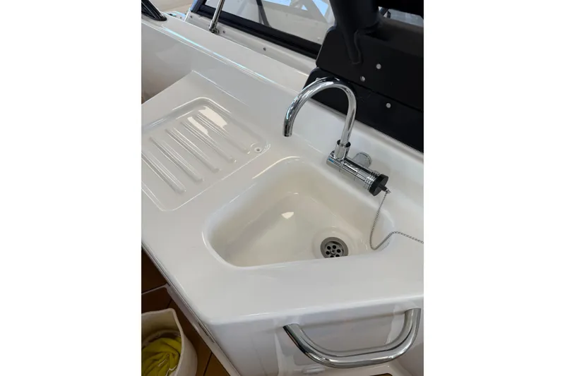 Slide: The Image of 2026 Bayliner D22 boat sink with chrome faucet and integrated drainboard. - 9