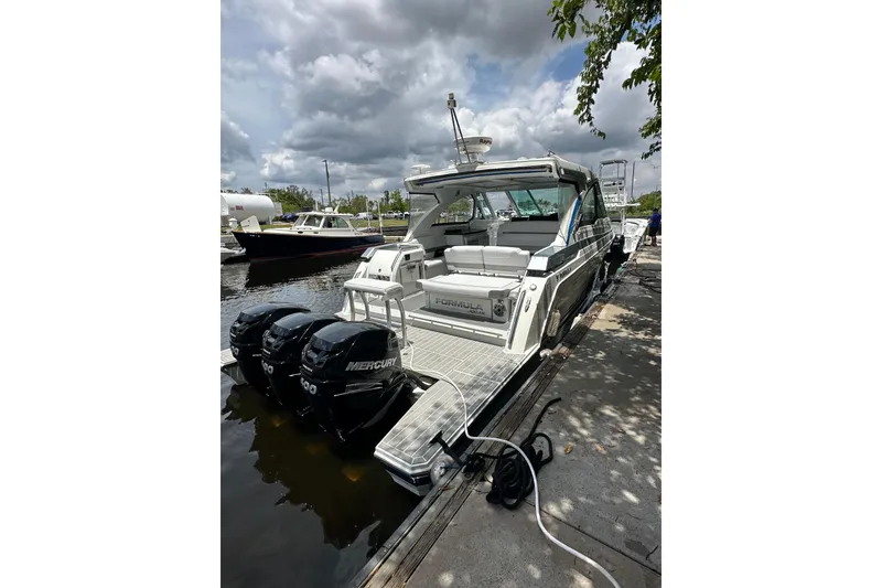 Slide: The Image of 2021 Formula 380 Super Sport Crossover OB docked with triple Mercury outboard engines. - 2