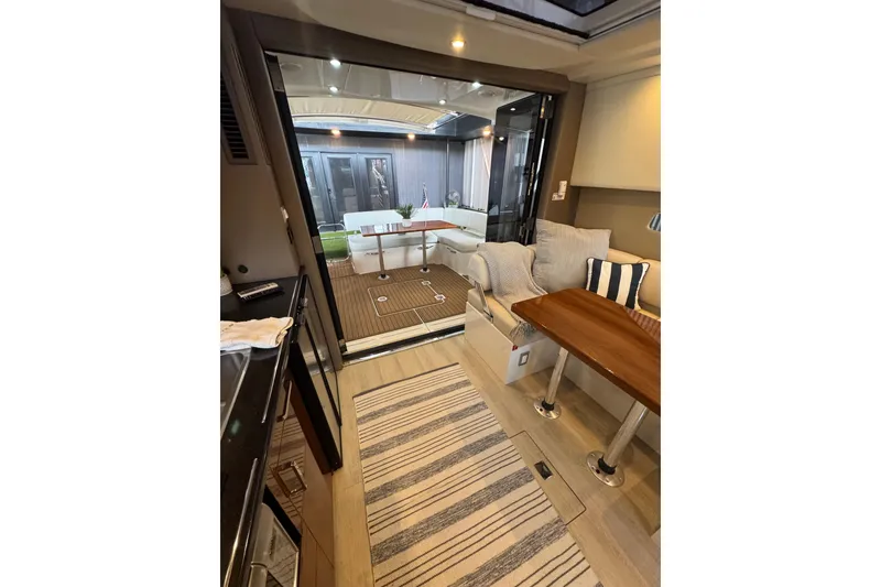 Slide: The Image of Interior of 2016 Carver C37 Coupe yacht with cozy seating and wooden table. - 12