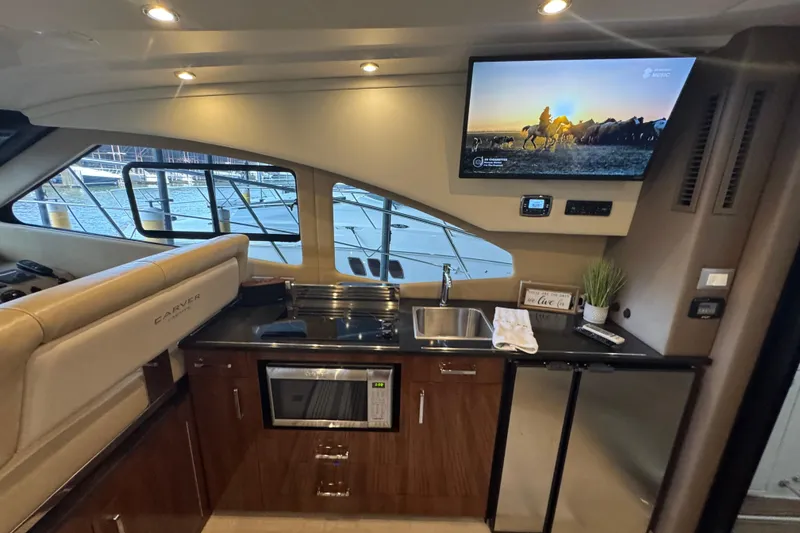 Slide: The Image of Interior of 2016 Carver C37 Coupe yacht with kitchenette and mounted TV. - 24