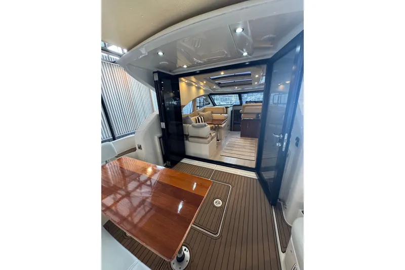 Slide: The Image of Interior view of 2016 Carver C37 Coupe yacht, featuring elegant seating and wooden table. - 26