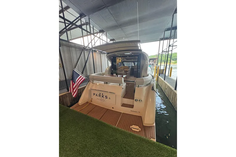 Slide: The Image of 2016 Carver C37 Coupe docked, displaying American flag, with "Parks & Wildlife" signage. - 28