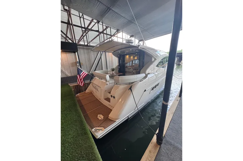 Slide: The Image of 2016 Carver C37 Coupe yacht docked, featuring sleek design and American flag. - 29