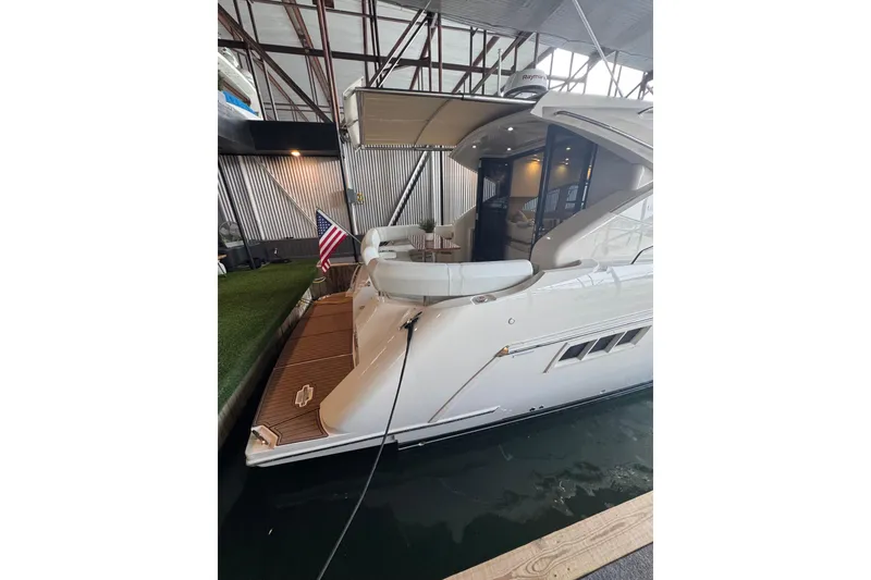 Slide: The Image of 2016 Carver C37 Coupe yacht docked in marina, featuring sleek design and American flag. - 30