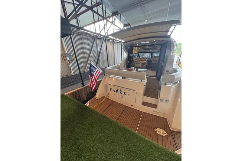 Slide: The Image of 2016 Carver C37 Coupe yacht docked indoors with American flag and open cabin view. - 31