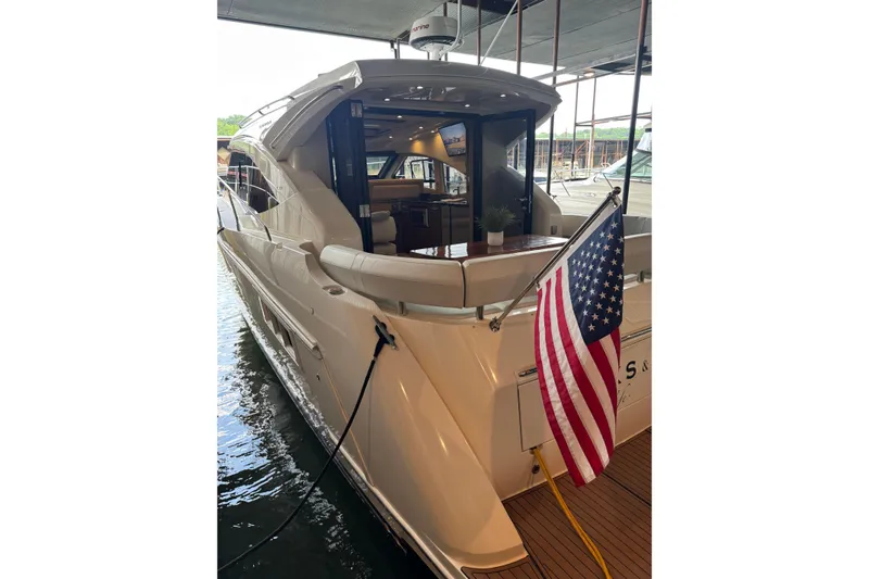 Slide: The Image of 2016 Carver C37 Coupe yacht docked, featuring sleek design and American flag. - 33