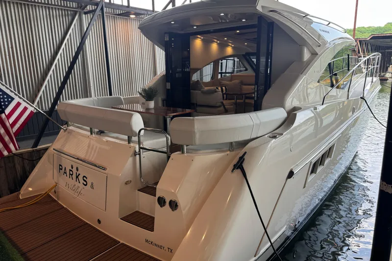 Slide: The Image of 2016 Carver C37 Coupe yacht docked, featuring elegant interior and American flag. - 34