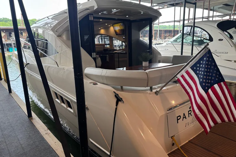 Slide: The Image of 2016 Carver C37 Coupe yacht docked with American flag displayed. - 37