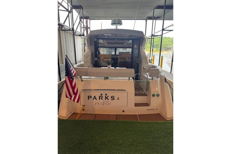 Slide: The Image of 2016 Carver C37 Coupe yacht docked, displaying an American flag and "Parks & Wildlife" signage. - 40
