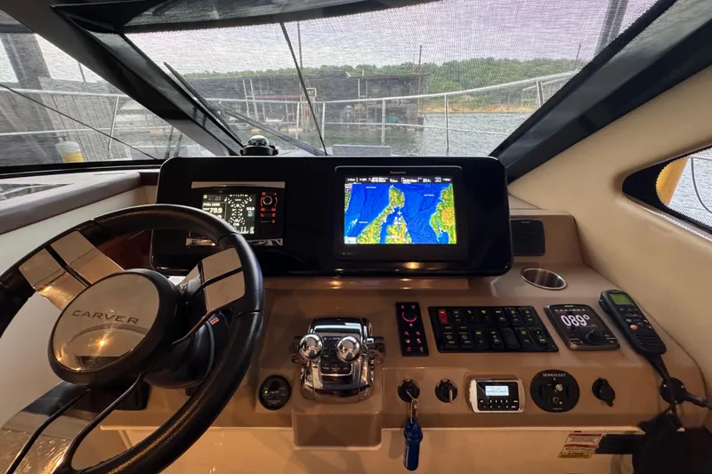 Slide: The Image of Helm of 2016 Carver C37 Coupe with navigation screens and controls. - 58