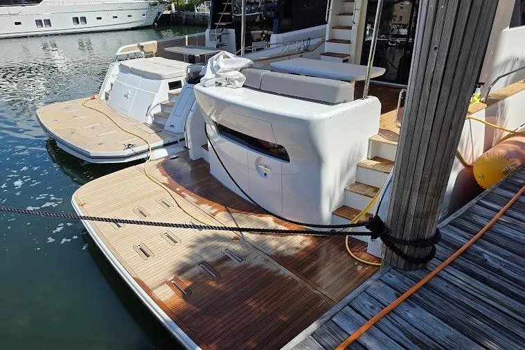 Slide: The Image of 2024 Sirena 58 Flybridge MY yacht docked, showcasing elegant wooden deck and modern design. - 10