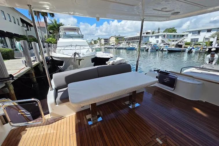 Slide: The Image of Luxurious 2024 Sirena 58 Flybridge yacht docked, featuring elegant outdoor seating and scenic marina view. - 13