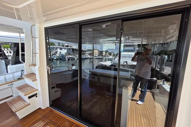 Slide: The Image of 2024 Sirena 58 Flybridge MY yacht with sleek glass doors and wooden deck. - 18