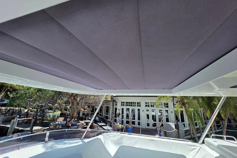 Slide: The Image of 2024 Sirena 58 Flybridge MY yacht with shaded deck area, docked near a building. - 35