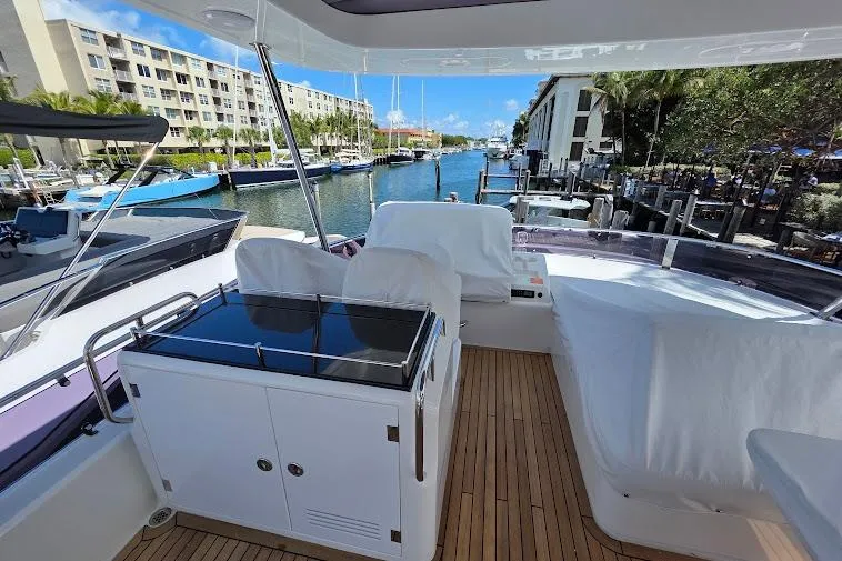 Slide: The Image of Flybridge view of 2024 Sirena 58 yacht docked at marina, featuring sleek design and spacious seating. - 36