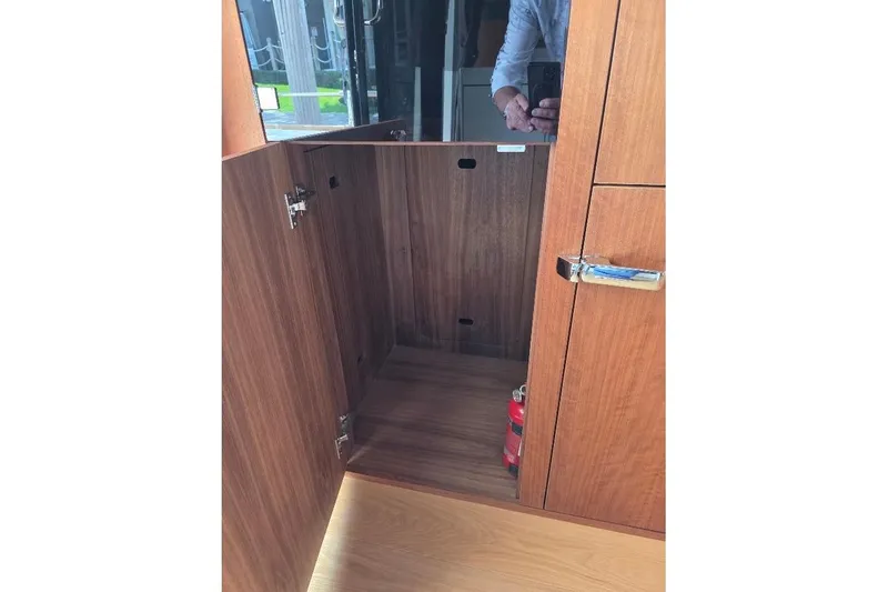Slide: The Image of Interior wooden cabinet on 2024 Sirena 58 Flybridge MY yacht, featuring a fire extinguisher. - 50