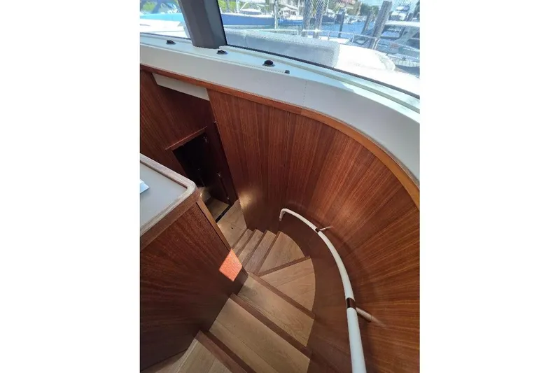 Slide: The Image of Curved wooden staircase inside 2024 Sirena 58 Flybridge MY yacht. - 62