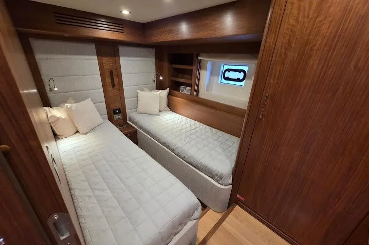 Slide: The Image of Luxurious twin cabin interior of 2024 Sirena 58 Flybridge MY yacht, featuring elegant wood finishes. - 69