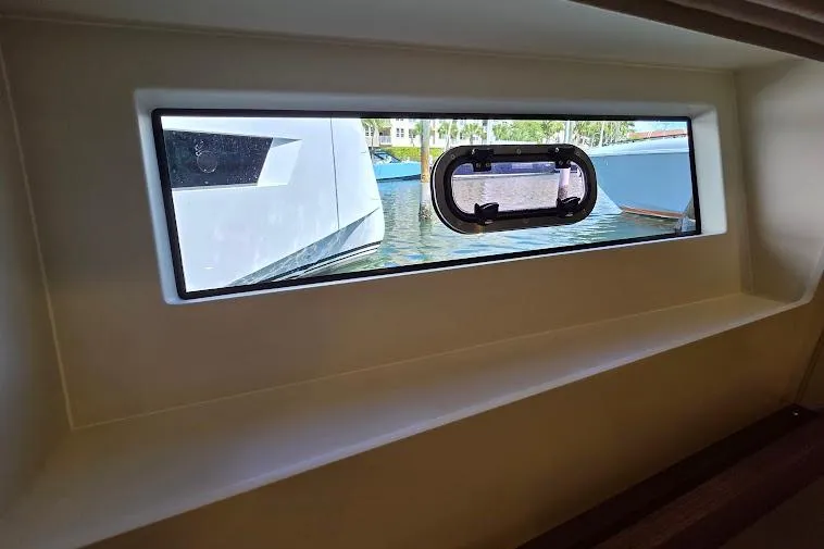 Slide: The Image of 2024 Sirena 58 Flybridge MY yacht window view, showcasing serene marina setting. - 73