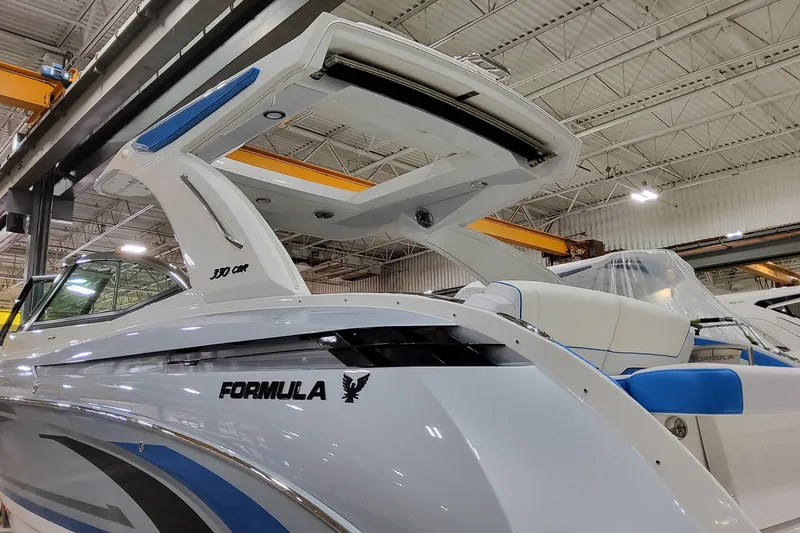 Slide: The Image of 2026 Formula 330 Crossover Bowrider I/O in a showroom, showcasing sleek design and modern features. - 5