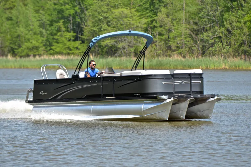 The Image of 2022 Qwest E822 pontoon boat cruising on a lake with lush green background. - 1