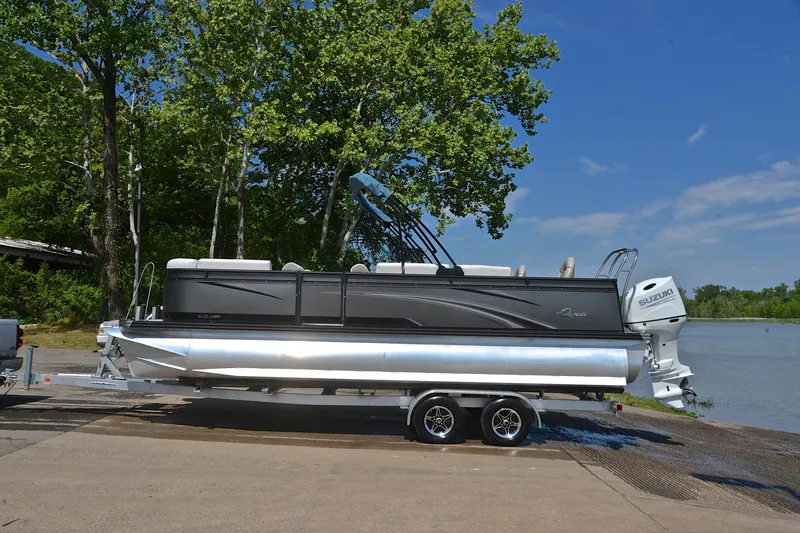 Slide: The Image of 2022 Qwest E822 pontoon boat on trailer by a lake, surrounded by trees. - 11