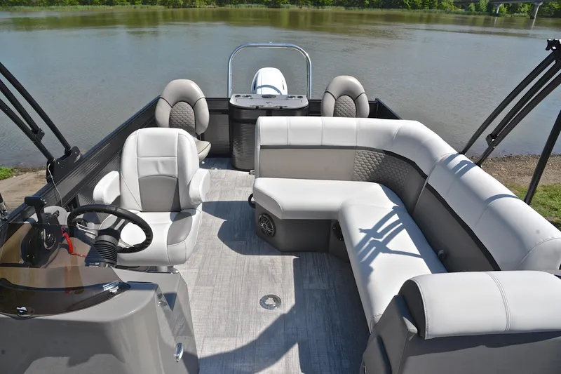 Slide: The Image of Luxurious 2022 Qwest E822 pontoon boat interior with plush seating and steering console by the water. - 23