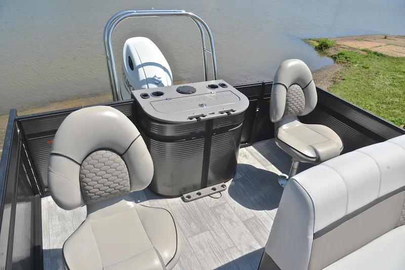 Slide: The Image of 2022 Qwest E822 pontoon boat interior with seating and console by the water. - 24