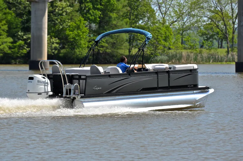 Slide: The Image of 2022 Qwest E822 pontoon boat cruising on a lake with lush greenery in the background. - 5