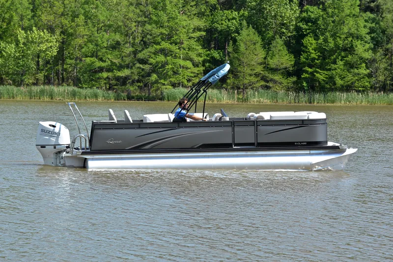 Slide: The Image of 2022 Qwest E822 pontoon boat cruising on a lake with lush green trees in the background. - 6