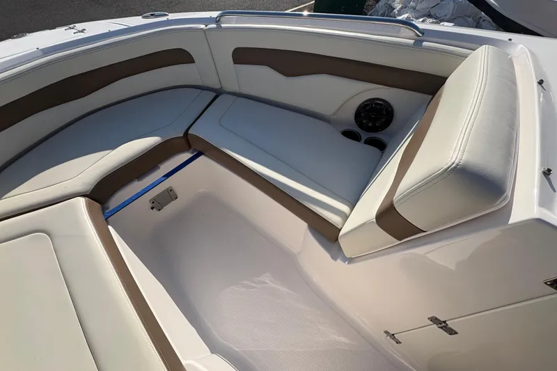 Slide: The Image of 2015 Chaparral 246 SSi boat interior with white and brown seating, cup holders, and speaker. - 14