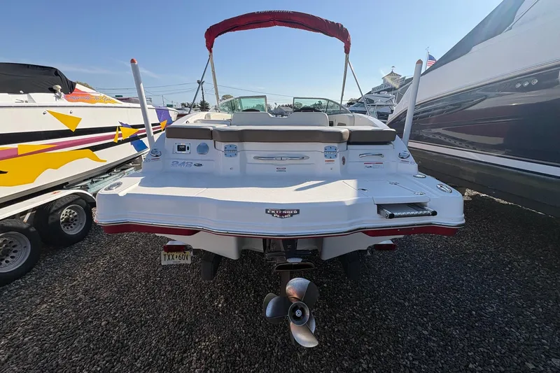 Slide: The Image of 2015 Chaparral 246 SSi boat, rear view, docked between other boats. - 4