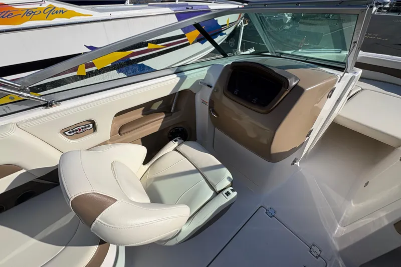 Slide: The Image of 2015 Chaparral 246 SSi boat interior with beige and white seating, dashboard, and windshield. - 8