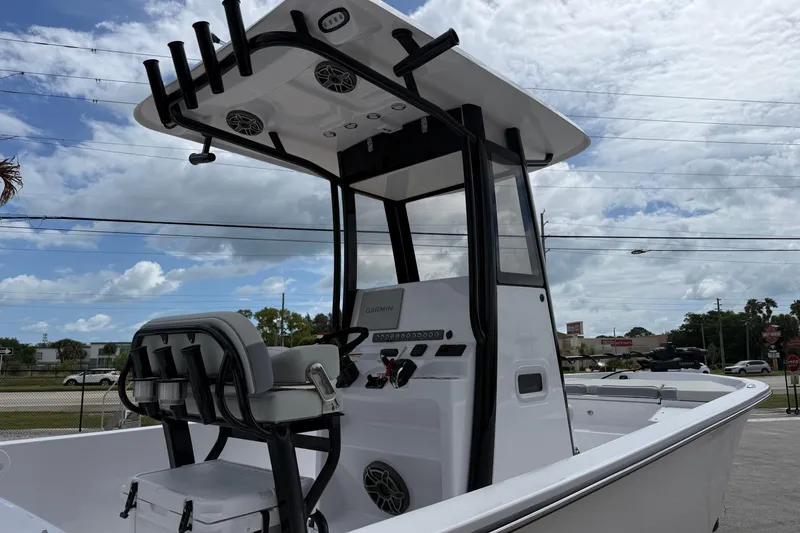 Slide: The Image of 2026 Action Craft 24 Coastal Bay boat with center console and T-top under cloudy sky. - 3