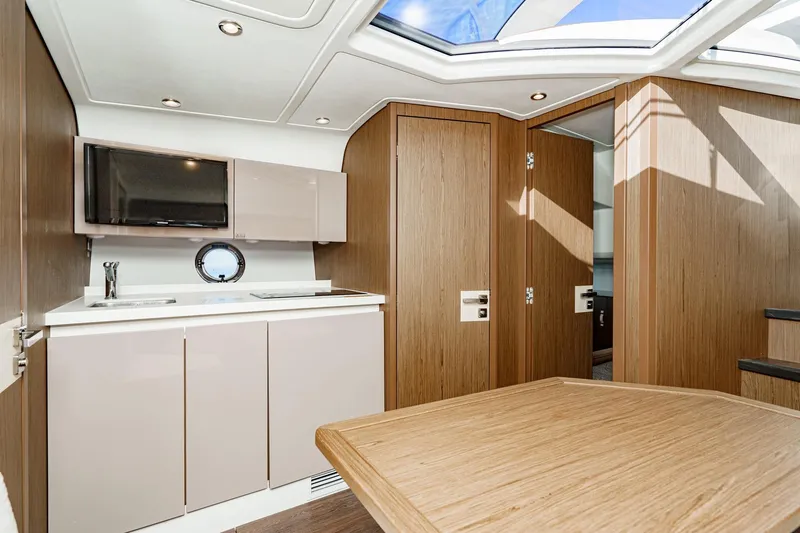 Slide: The Image of Interior of 2018 Beneteau Gran Turismo 40 yacht, featuring modern kitchen and wooden cabinetry. - 35