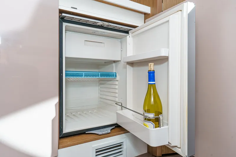 Slide: The Image of Open fridge on Beneteau Gran Turismo 40 yacht, 2018, with wine bottle inside. - 37