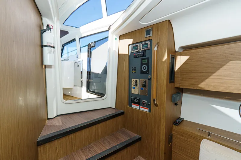 Slide: The Image of Interior view of 2018 Beneteau Gran Turismo 40 yacht, featuring control panel and wooden stairs. - 47