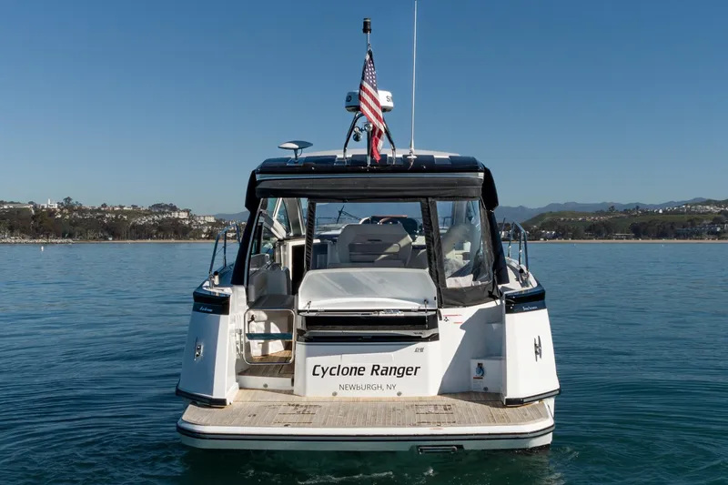 Slide: The Image of 2018 Beneteau Gran Turismo 40 yacht on calm water, rear view with American flag. - 64