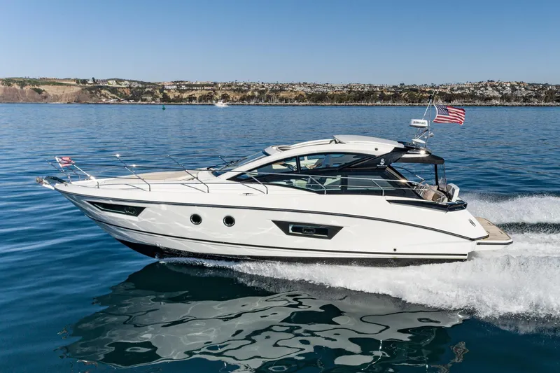 Slide: The Image of 2018 Beneteau Gran Turismo 40 yacht cruising on calm waters, coastal landscape in background. - 68